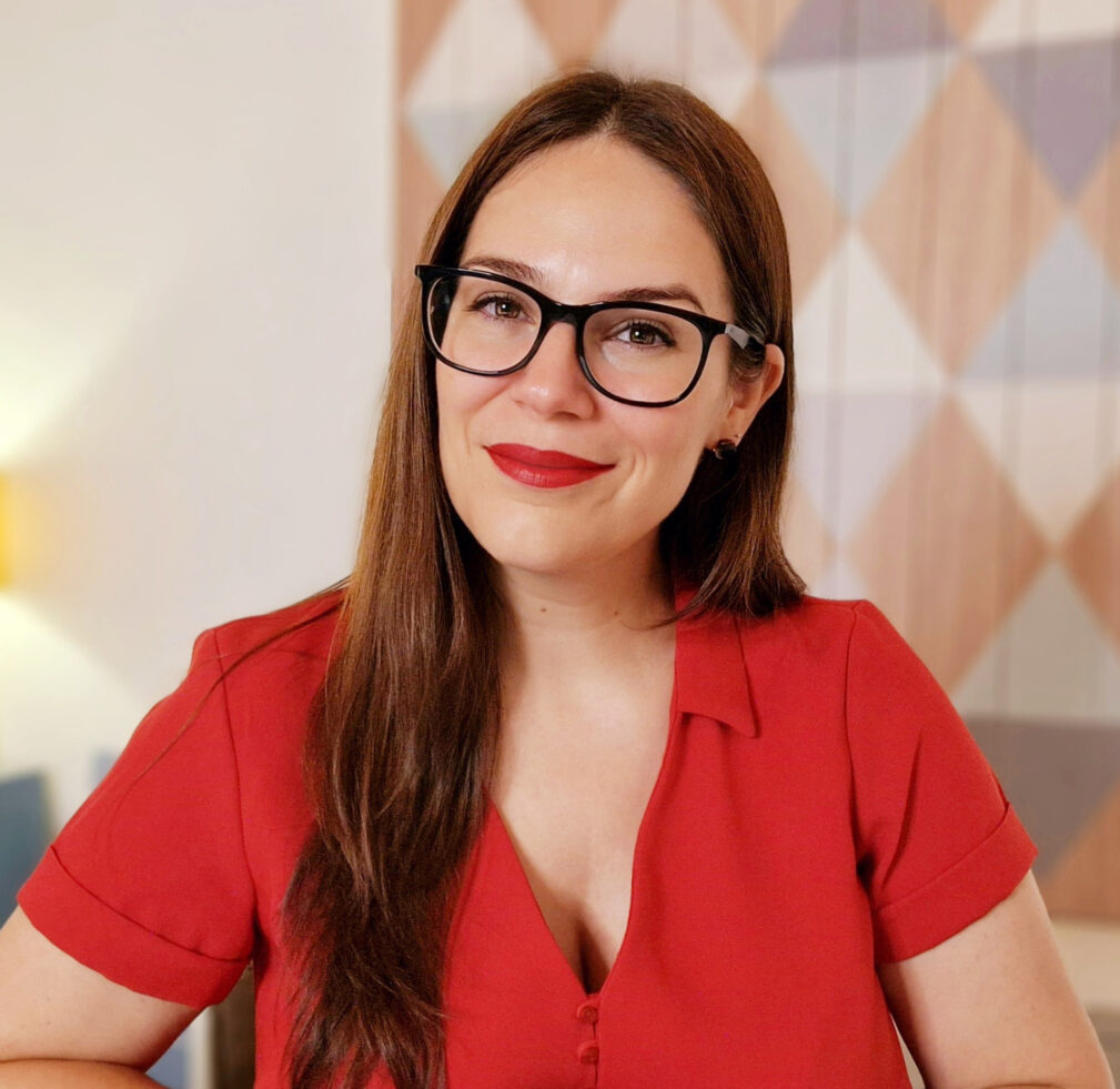 Foto de Mamen Jiménez en su consulta, sonriendo, y con un vestido rojo